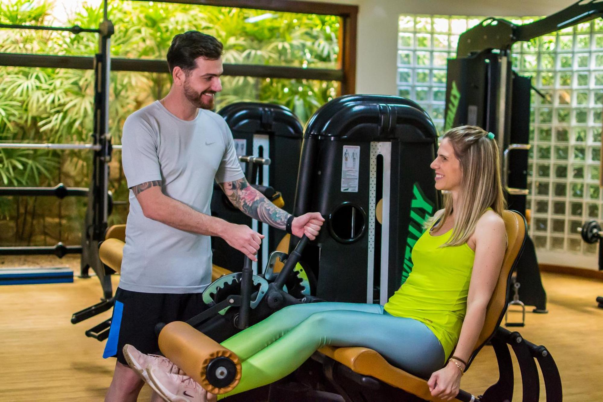 Blue Tree Thermas De Lins Resort Екстер'єр фото Personal trainer assisting a woman on a leg press machine